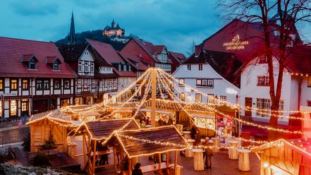 Lichterketten erstrahlen zum Wintermarkt in Wernigerode den Platz an der Blumenuhr hinter dem historischen Rathaus.