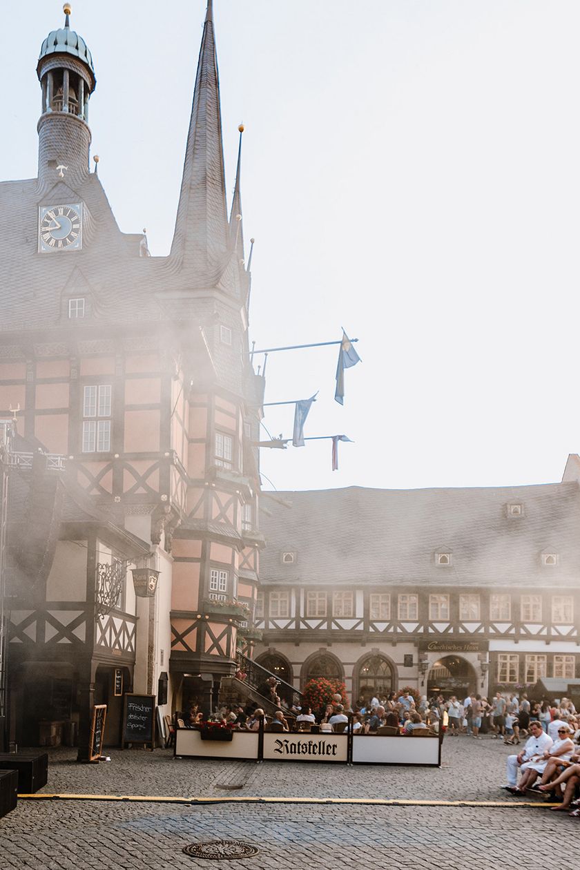Publikum sitzt auf Bänken vor einer Bühne auf dem Marktplatz zum Rathausfest in Wernigerode.