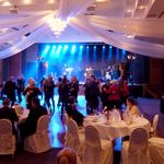 Im Saal des Harzer Kultur und Kongresszentrums stehen Tische mit Stühlen. Auf der Tanzfläche vor der Bühne wird getanzt.