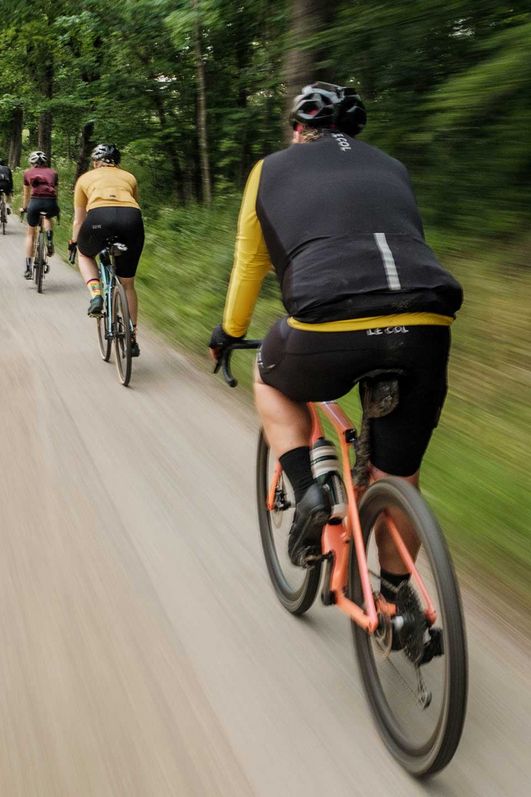 Teilnehmende am Gravel Bike Fest in Schierke fahren eine Schotterweg im wald entlang
