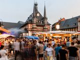 Vor dem Rathaus auf dem Marktplatz in Wernigerode stehen viele Menschen an Gastronomieständen zum Rathausfest in Wernigerode.