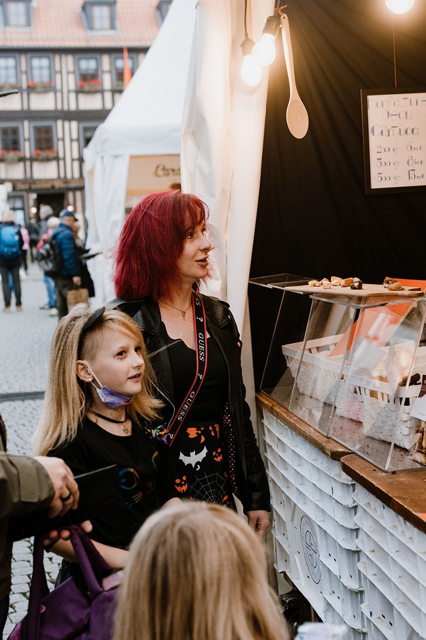 Eine Familie steht zum Schokoladenfestival chocolART an einem Verkaufsstand auf dem Marktplatz in Wernigerode.