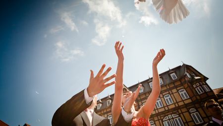 Ein Hochzeitspaar läßt eine Taube auf dem Marktplatz in Wernigerode steigen.