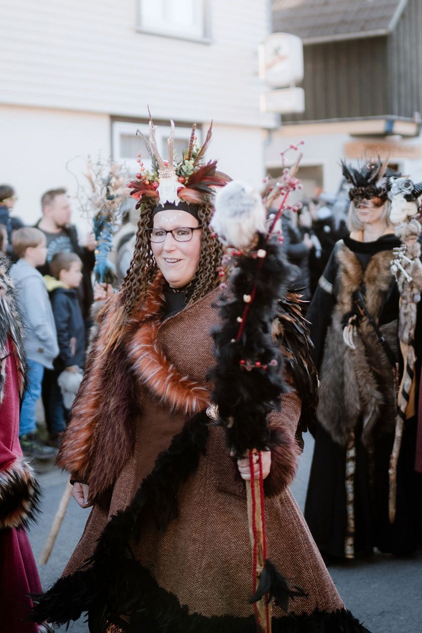 Als Hexen verkleidete Personen laufen während des Hexenumzuges zur Walpurgis in Schierke durch die Straße.
