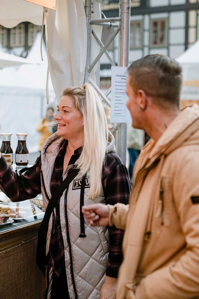 Ein Paar steht vor einem Verkaufsstand zum Schokoladenfestival chocolART in Wernigerode auf dem Marktplatz.