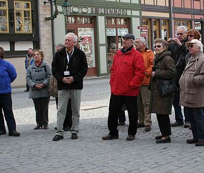 Eine Gruppe von Personen steht vor dem Rathaus auf dem Marktplatz in Wernigerode