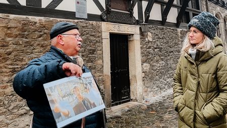 Ein Stadtführer zeigt Bilder während einer Stadtführung in Wernigerode