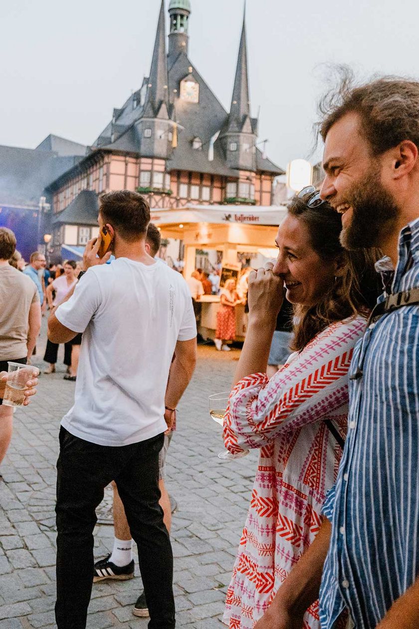 Besucher des Rathausfest in Wernigerode stehen auf dem Marktplatz und unterhalten sich.