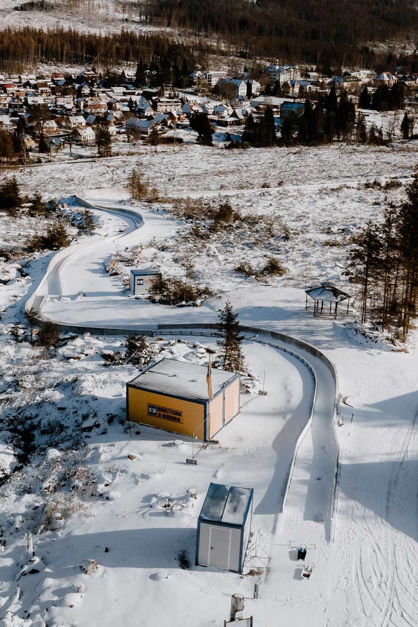 Luftaufnahme von der Rennrodelbahn in Schierke. Im Hintergrund ist der Ort zu erkennen.